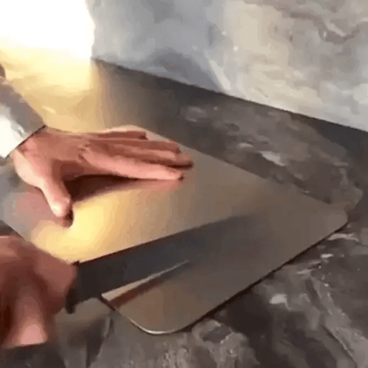 Person using a titanium cutting board to cut through food, showing its robust, long-lasting performance.