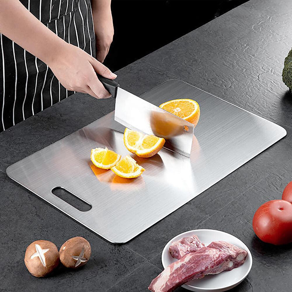 Person slicing oranges on a Titanium Cutting Board in a kitchen setting