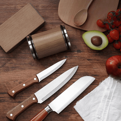 Magnetic rolling knife sharpener placed next to various kitchen knives on wooden countertop