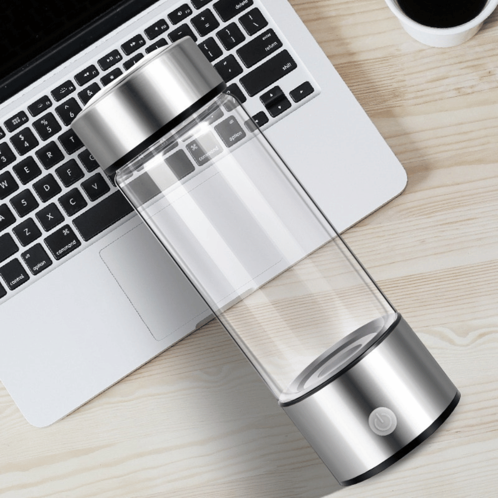 Sleek Portable Hydrogen Water Generator lying beside a laptop on a desk – ideal for office and travel use.